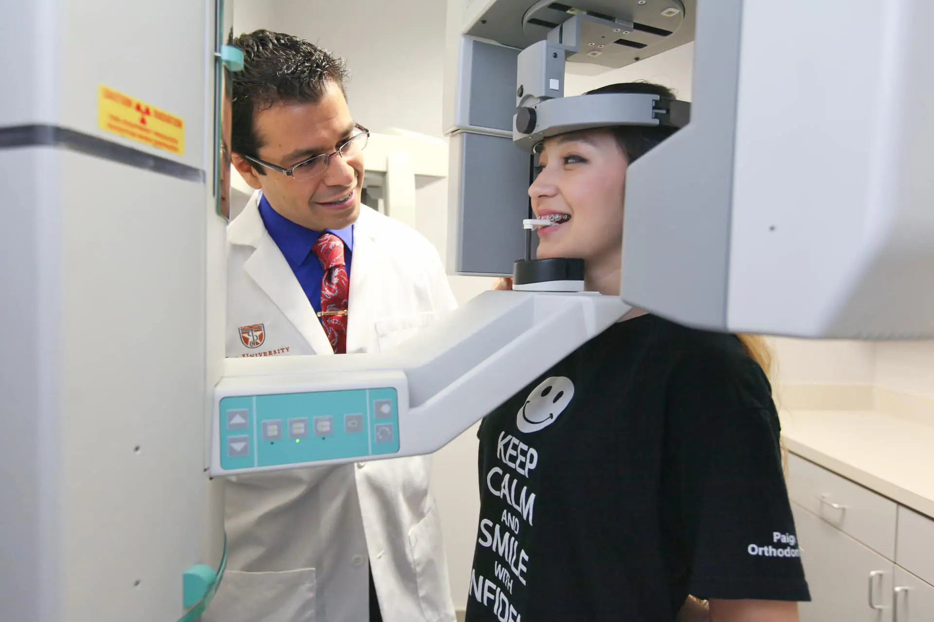 During a panoramic X-ray procedure in a Kingwood TX dental office, a dental professional assists a patient considering braces.