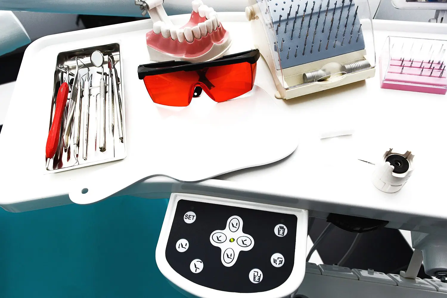 On the control panel of a dental tray in Kingwood TX, you'll find dental tools, protective eyewear, a dental model, and a Herbst Appliance neatly arranged.