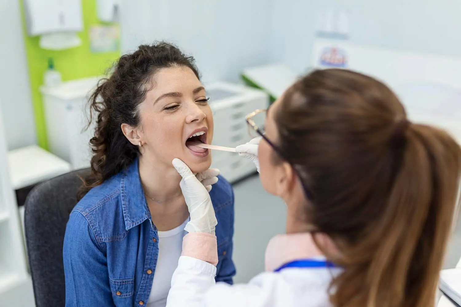 a doctor uses a tongue depressor to examine a patient Mouth Breath at Paige Orthodontics in Kingwood