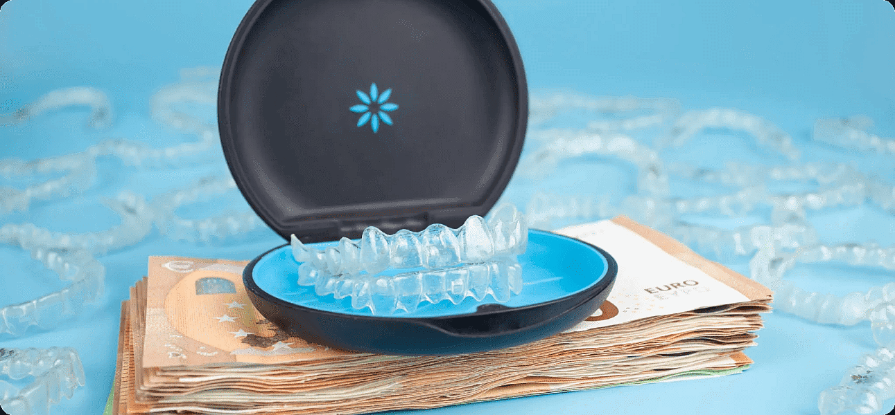 Against a blue backdrop, clear dental aligners in an open case sit atop euro banknotes, with more aligners scattered nearby. This scene subtly suggests the Invisalign cost at Paige Orthodontics in Kingwood, TX.