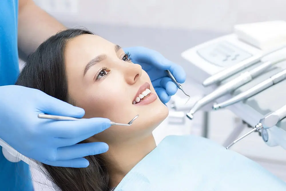 a woman smiles in a dental chair for Orthodontic Treatment at Paige Orthodontics in Kingwood, TX