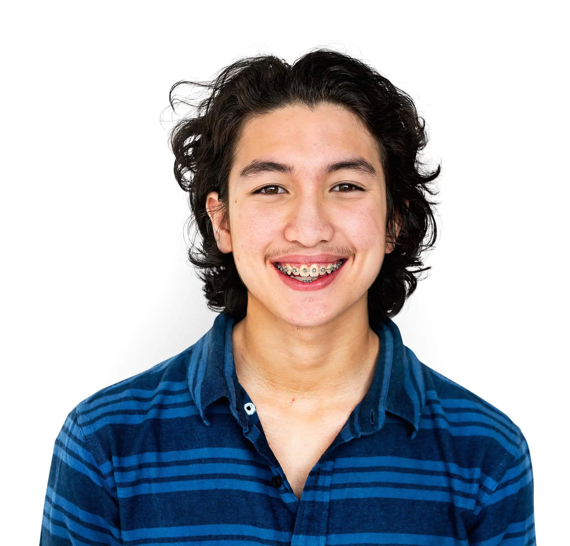 An adult with long curly hair and metal braces, wearing a blue and black striped shirt, smiles with benefits of adult braces at Paige Orthodontics in Kingwood, TX